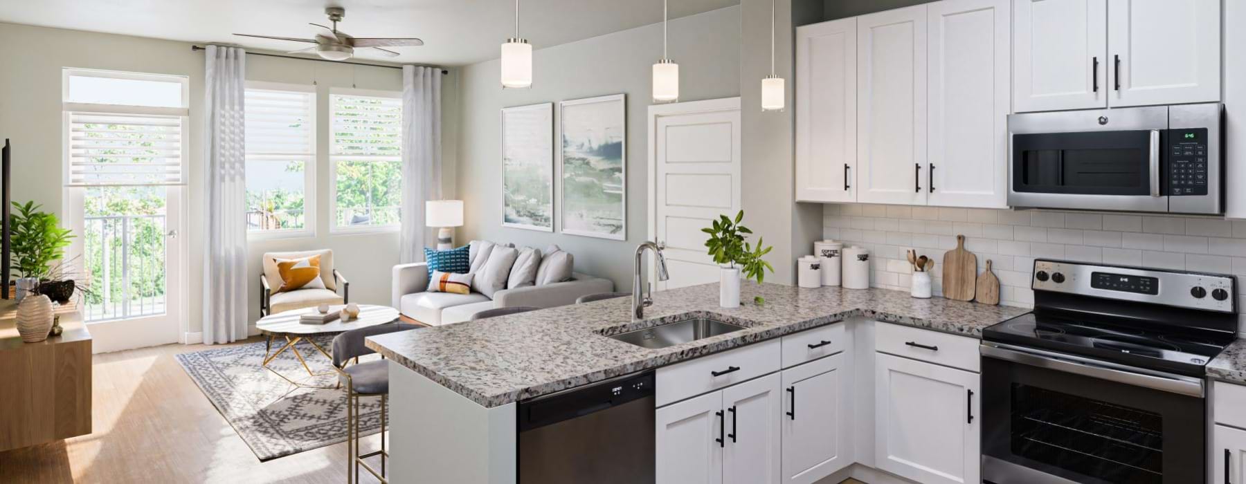 a kitchen with white cabinets and wood-style flooring at Amberlin South Naples in Naples, Florida